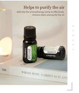 Vue détaillée de flacons d'huiles essentielles 10ml sur livres avec lumière d'ambiance