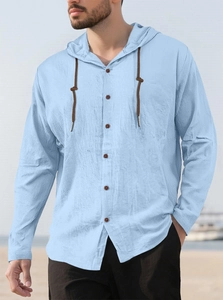 Detail of light blue cotton hoodie shirt with drawstring hood and brown buttons on beach