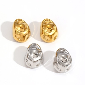 Macro shot of irregular pebble-shaped stud earrings in polished gold and silver steel