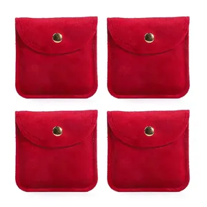 Set of four red velvet jewelry pouches with gold snap buttons in symmetric layout