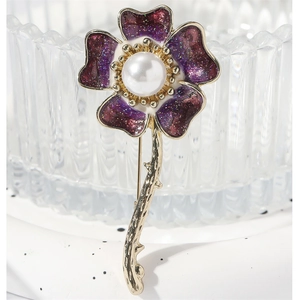 Elegant purple enamel daisy brooch with a central pearl and glittering golden accents