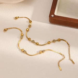 Bracelets cœur en acier inoxydable doré avec zircons sur fond beige de luxe élégant