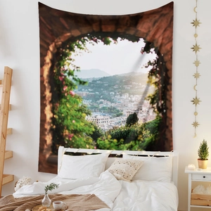 Detail of bohemian tapestry featuring a floral archway with a Mediterranean coastal town view