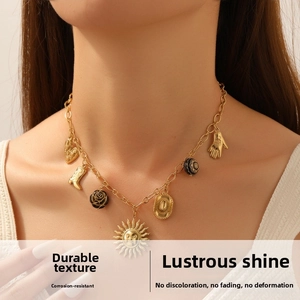 Close-up of vintage gold-plated necklace featuring sun mask and western boot charms