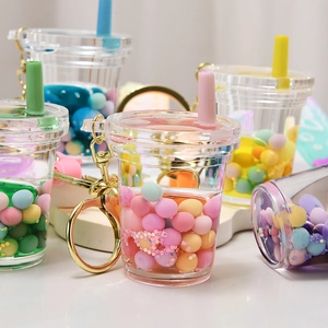 Close-up of acrylic liquid quicksand keychains with colorful pearls and tea cup charms