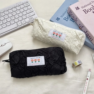 Minimalist textured quilted pencil cases in black and cream white with floral woven labels