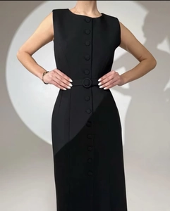 Detail of a black sleeveless midi dress featuring button closure and a matching waist belt