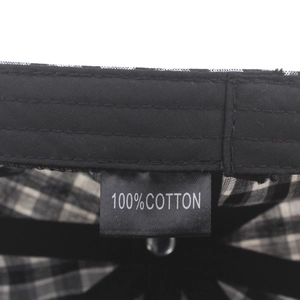 Detailed macro view of 100% cotton label and stitching inside plaid beret hat