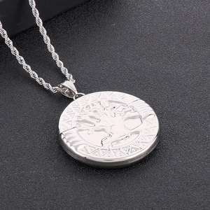 Macro detail of silver tree of life pendant with geometric borders on twist chain