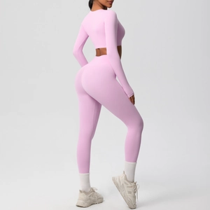 Detail view of pink high-stretch yoga set featuring long sleeve crop top and high waist leggings