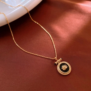 Détail du pendentif rose dorée sur soie foncée, bijou rétro de style français chic
