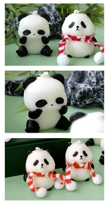 Detailed close-up of cute panda shaped candles with scarves and natural bamboo leaf decor