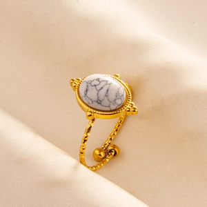 Detail of gold open ring with twisted texture and white oval marble-style stone inlay