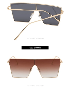 Detail view of large square frame sunglasses with golden metal frame in brown gradient lens