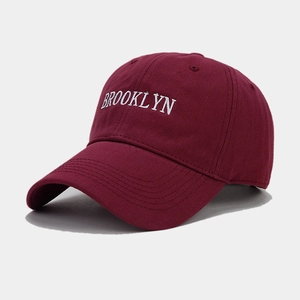 Close-up of white Brooklyn embroidery on a burgundy cotton vintage baseball cap