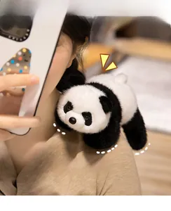 Close-up of a soft plush panda toy with fluffy white fur resting on a person's shoulder