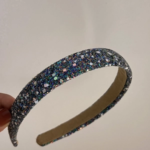 Detail of sequin headband showing colorful glitter and silver geometric sequins on a beige base