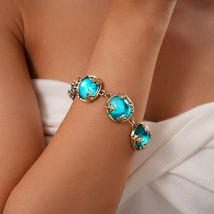 Détails de gros plan du bracelet vintage doré avec pierres en résine bleue sur mannequin