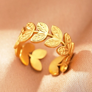 Detailed macro view of adjustable golden olive leaf ring with brushed metal texture