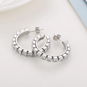 Detail view of silver hoop earrings with dense oval cubic zirconia pavé settings