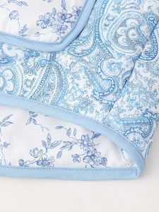 Close-up of blue floral paisley quilted fabric showing detailed stitching and reinforced edges