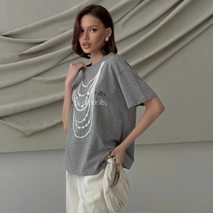 Detail of grey cotton T-shirt featuring a pearl necklace print and artistic lettering