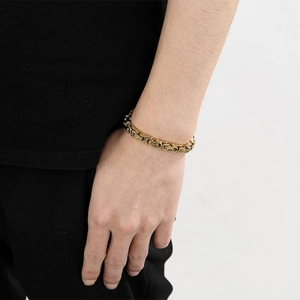 Dettaglio del bracciale bizantino in acciaio inossidabile dorato al polso maschile