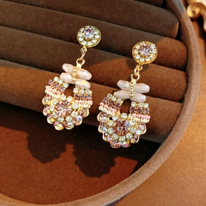 Macro shot of vintage round crystal earrings with pink beads in a brown velvet gift box