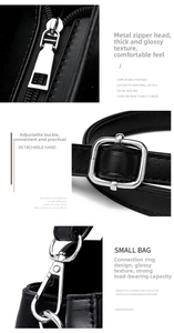 Detail view of silver hardware, adjustable buckles and smooth leather texture of a black crossbody bag