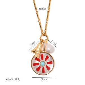 Gold multi-pendant necklace with red star enamel, turquoise bead, and white pearl drop