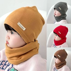 Dettaglio dei set cappello e sciarpa in maglia per neonati in colori giallo, grigio e rosso