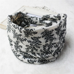 Detail of wide elastic headband featuring black and white leaf print on soft fabric texture