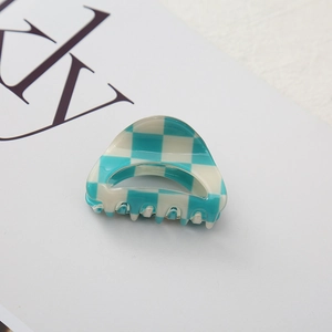 Detail shot of the blue and white checkerboard hair claw clip with metal spring