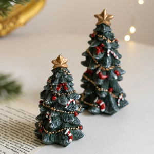 Mini resin dark green Christmas trees with gold stars and red bows for festive desktop decor