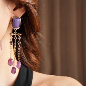 Details von Vintage-Ohrringen mit lila Stein und bronzefarbenen Troddeln am Modell
