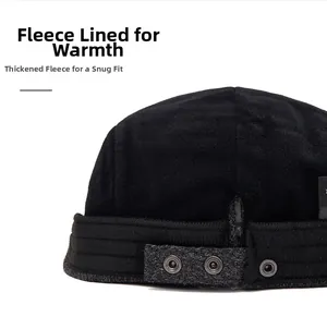 Detail view of the black wool cap showing soft gray fleece lining and metal snap buckle