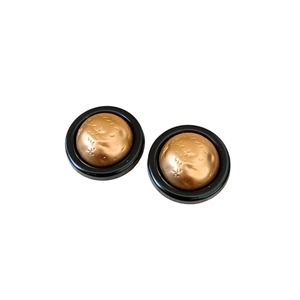 Minimalist vintage gold textured earrings with black circular frames on a white background