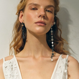 Détails de boucles d'oreilles pompons asymétriques avec breloques marguerites bicolores