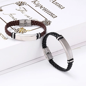 Detail of black and brown braided leather bracelets with stainless steel id plate