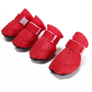 Close-up of four red breathable mesh dog shoes with secure white velcro straps