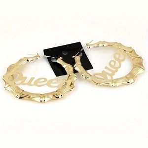 Details goldener Oversize-Creolen mit Bambus-Struktur und Queen-Schriftzug-Design