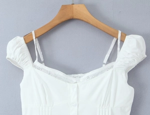 Close-up of white puff sleeve top with delicate lace trim and heart-shaped neckline