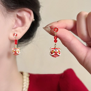Detail view of Chinese New Year style lion dance tassel earrings with red enamel beads
