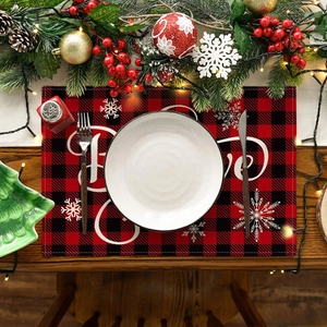 Close-up of a red and black buffalo plaid Christmas placemat with snowflake and Love text