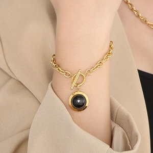 Détail du bracelet chaîne en or avec fermoir à bascule OT et pendentif en cristal noir