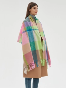 Detail of colorful plaid scarf with soft fringe showing pastel pink and mint knit texture