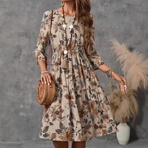 Detail of floral printed beige dress featuring three-quarter sleeves and cotton linen texture