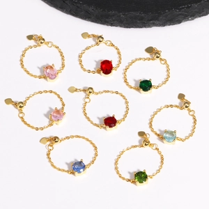 Adjustable gold chain ring featuring colorful zircons on a textured black rock base