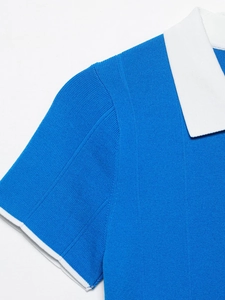 Dettaglio ravvicinato dell'abito a polo in maglia blu con colletto e polsini bianchi