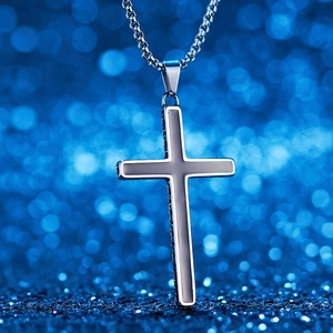 Macro view of silver stainless steel cross pendant with black textured inlay on a sturdy chain